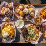 We Tried 10 Trending Fair Foods: Here's the Honest Verdict 3 Wide overhead shot of food festival table covered with diverse dishes